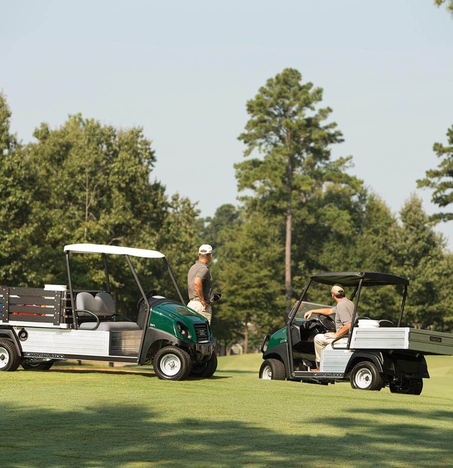 New Utility Car being used on golf green with golfers nearby.